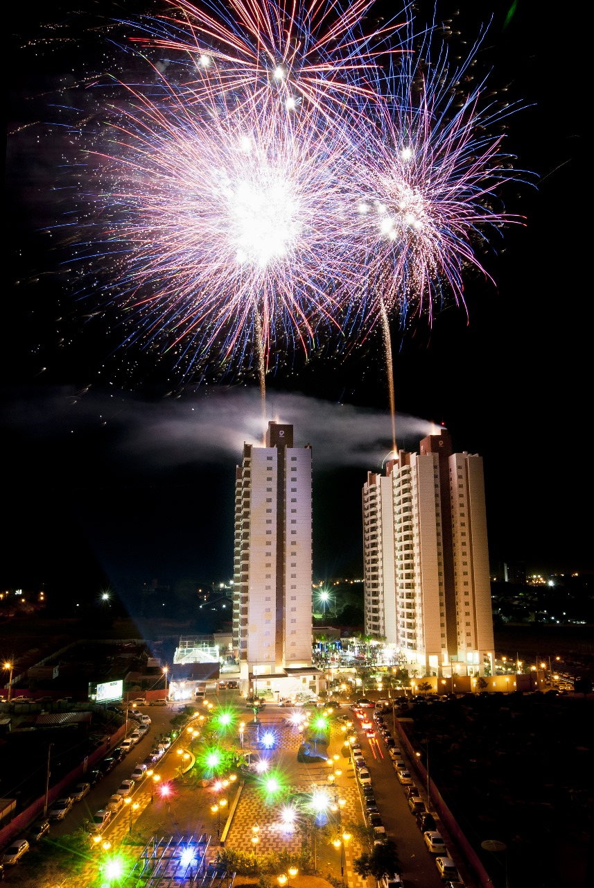 Queima de fogos sobre as torres de um lançamento imobiliário em Londrina, com a praça iluminada e o público embaixo